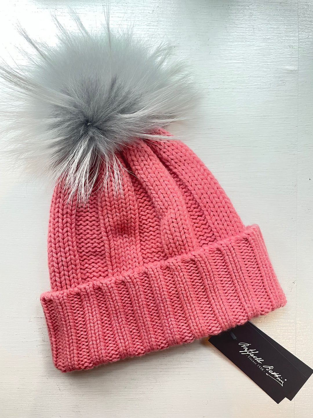 Cashmere ribbed beanie in pink with grey raccoon pom pom