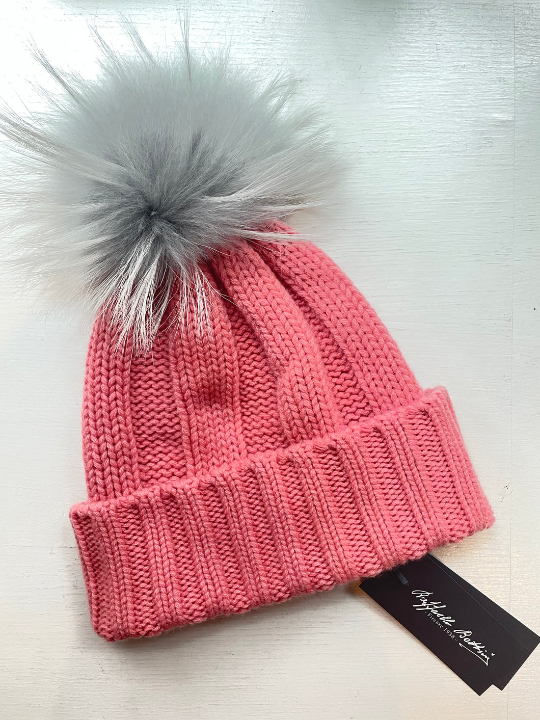 Cashmere ribbed beanie in pink with grey raccoon pom pom